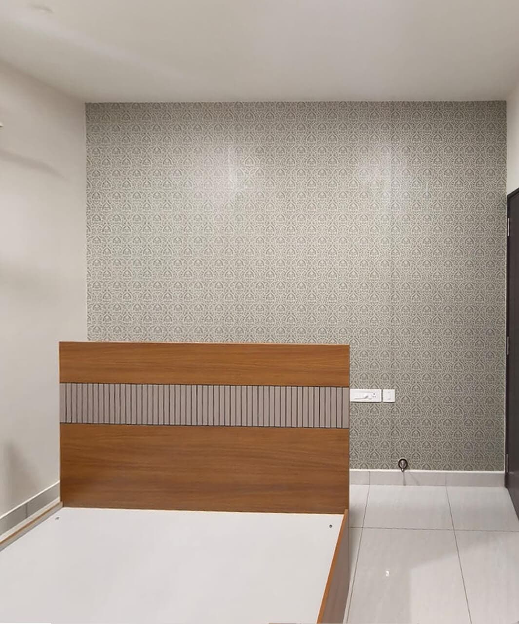 Bedroom accent wall finished in a grey damask wallpaper installation